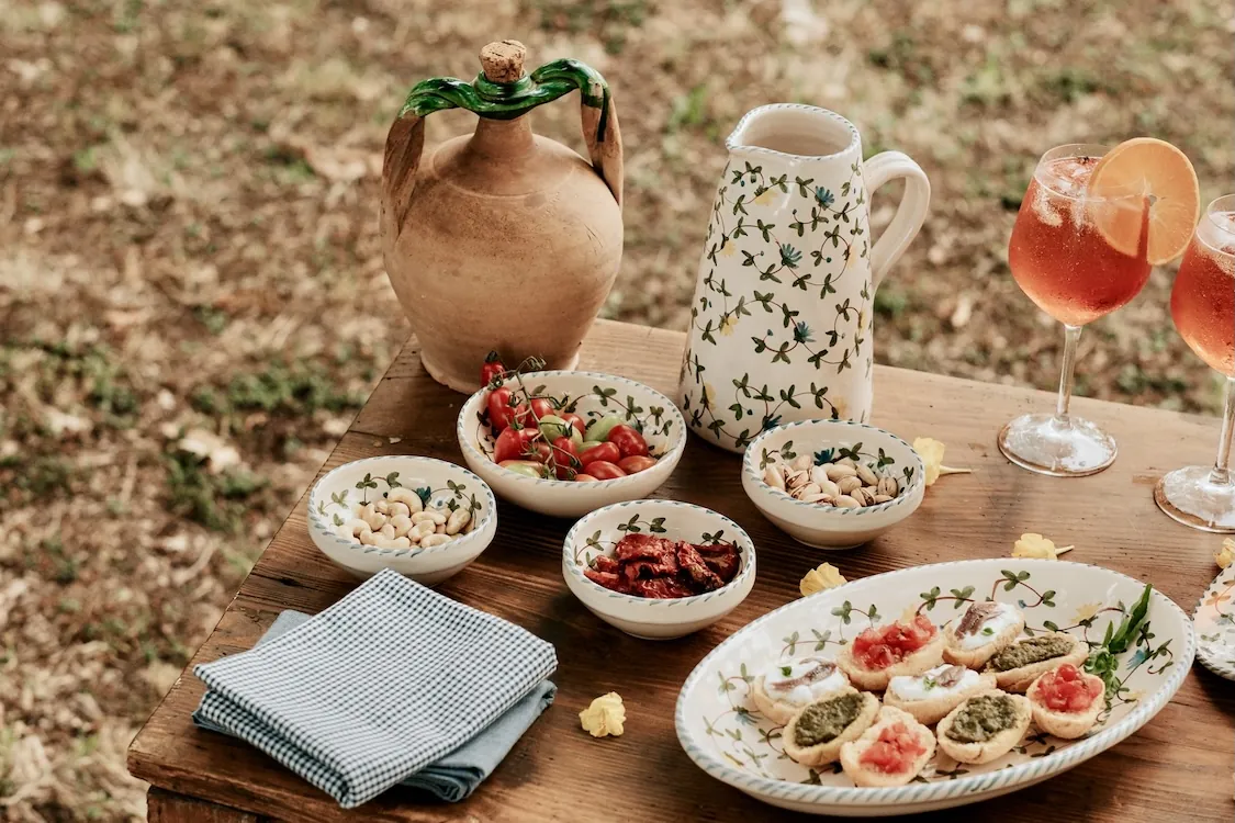 Apéritif servi dans des bols et une carafe peints à la main