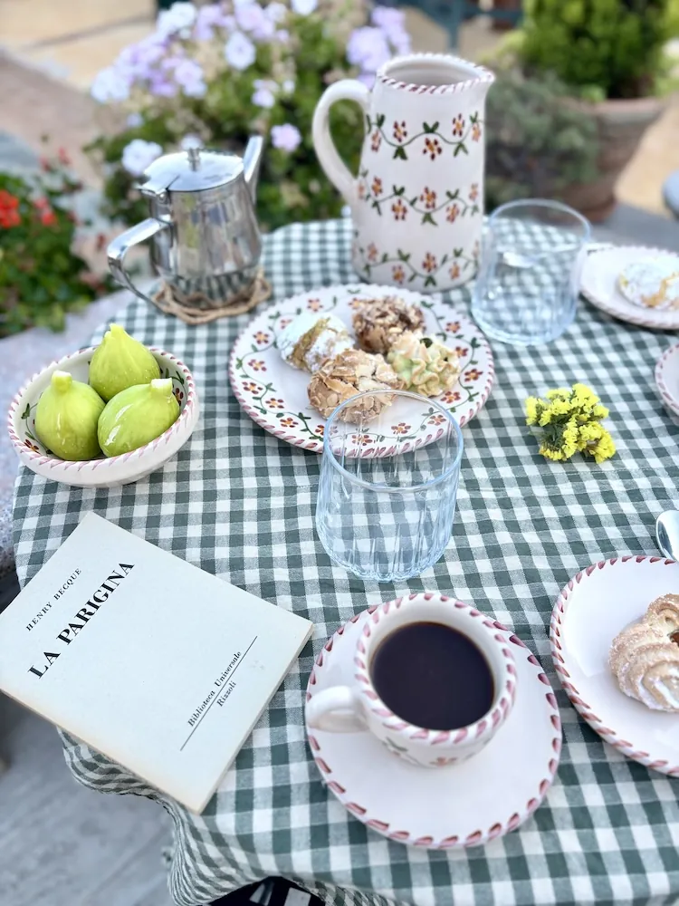 Petit-déjeuner servi en terrasse sur une nappe vichy