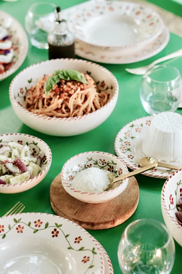 Table verte dressée avec pâtes et assiettes Profumo di Primavera