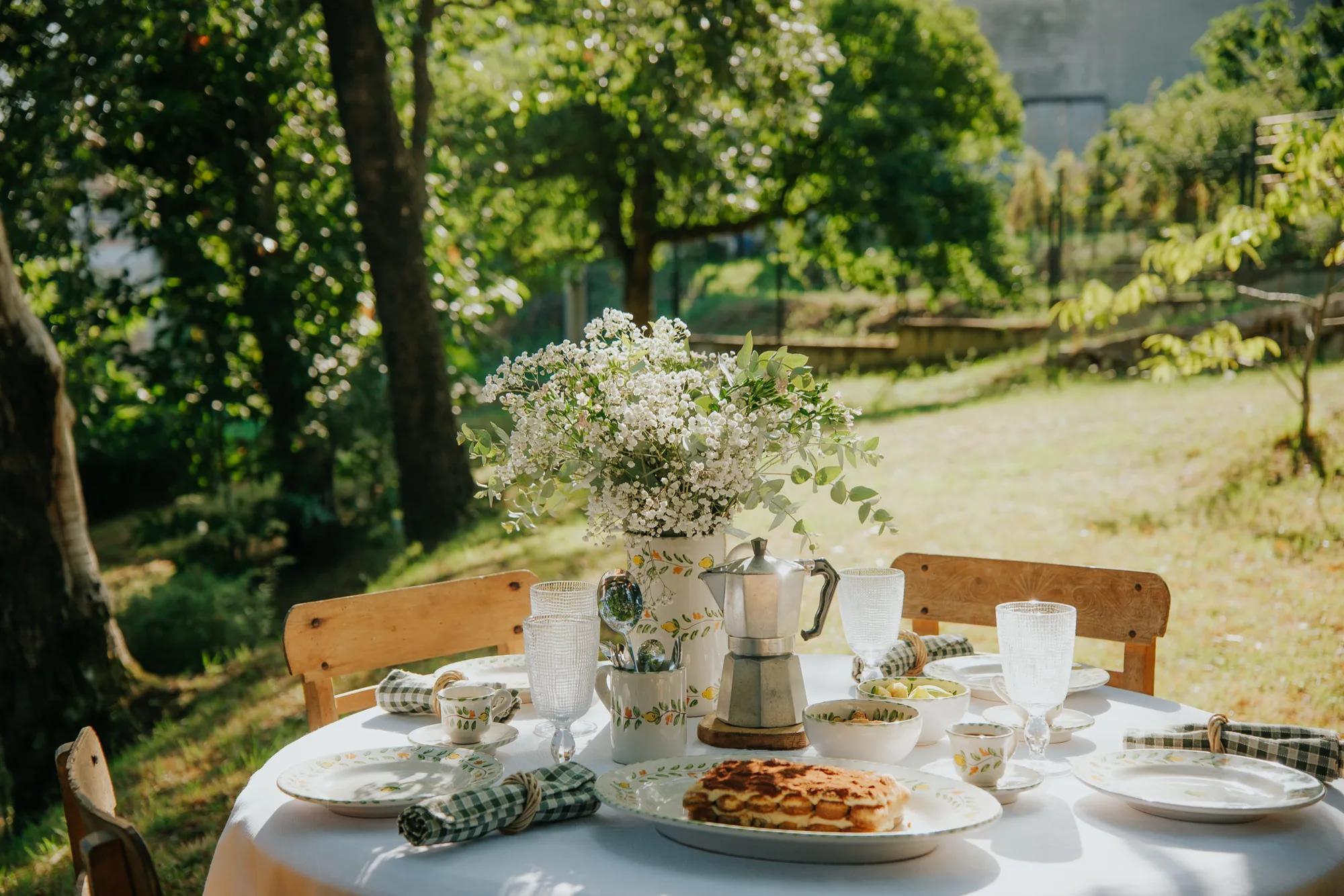 Table ronde dressée au jardin avec la vaisselle Sapore di Limone