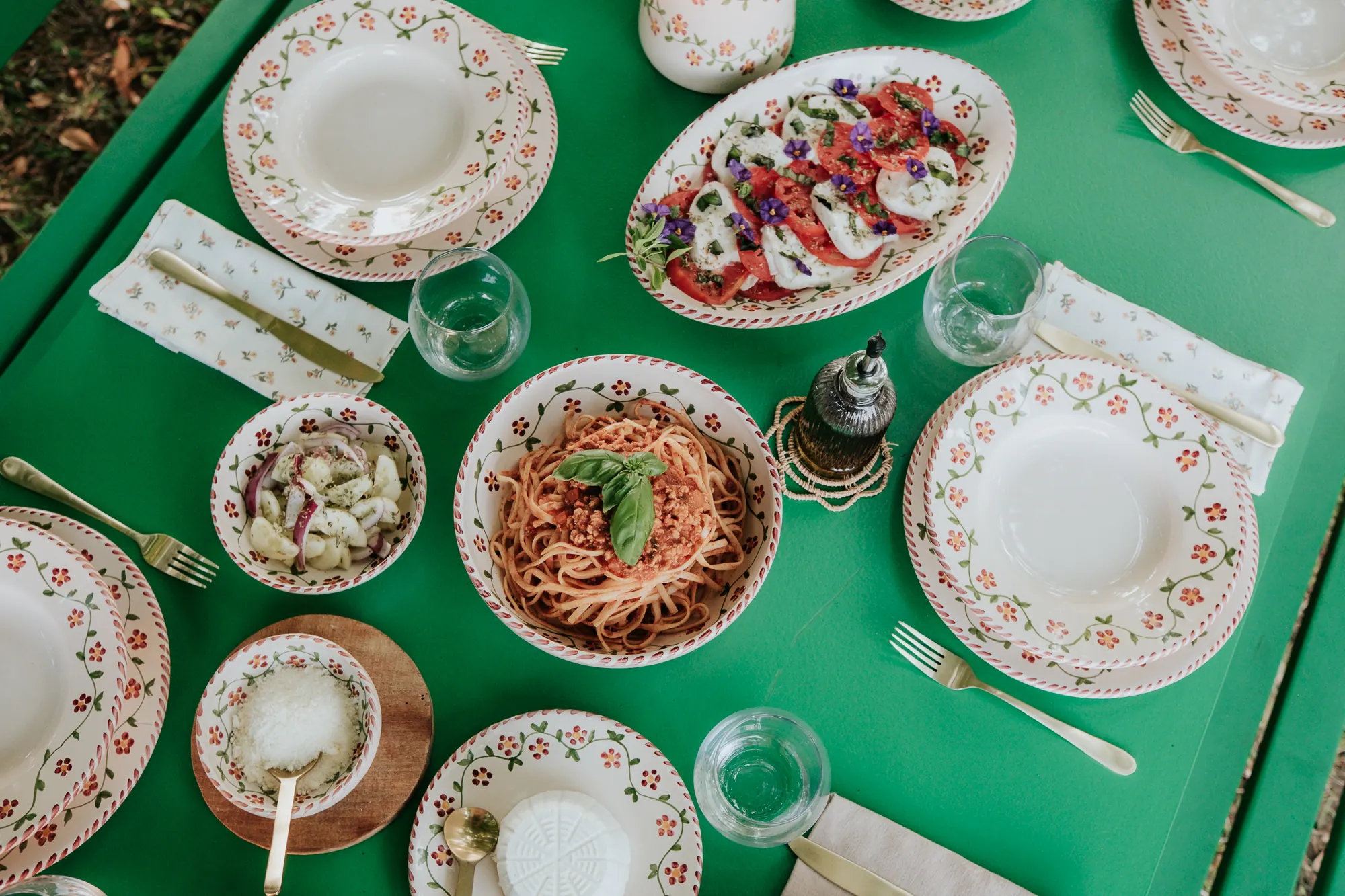 Table verte vue du dessus, pâtes et assiettes Profumo di Primavera