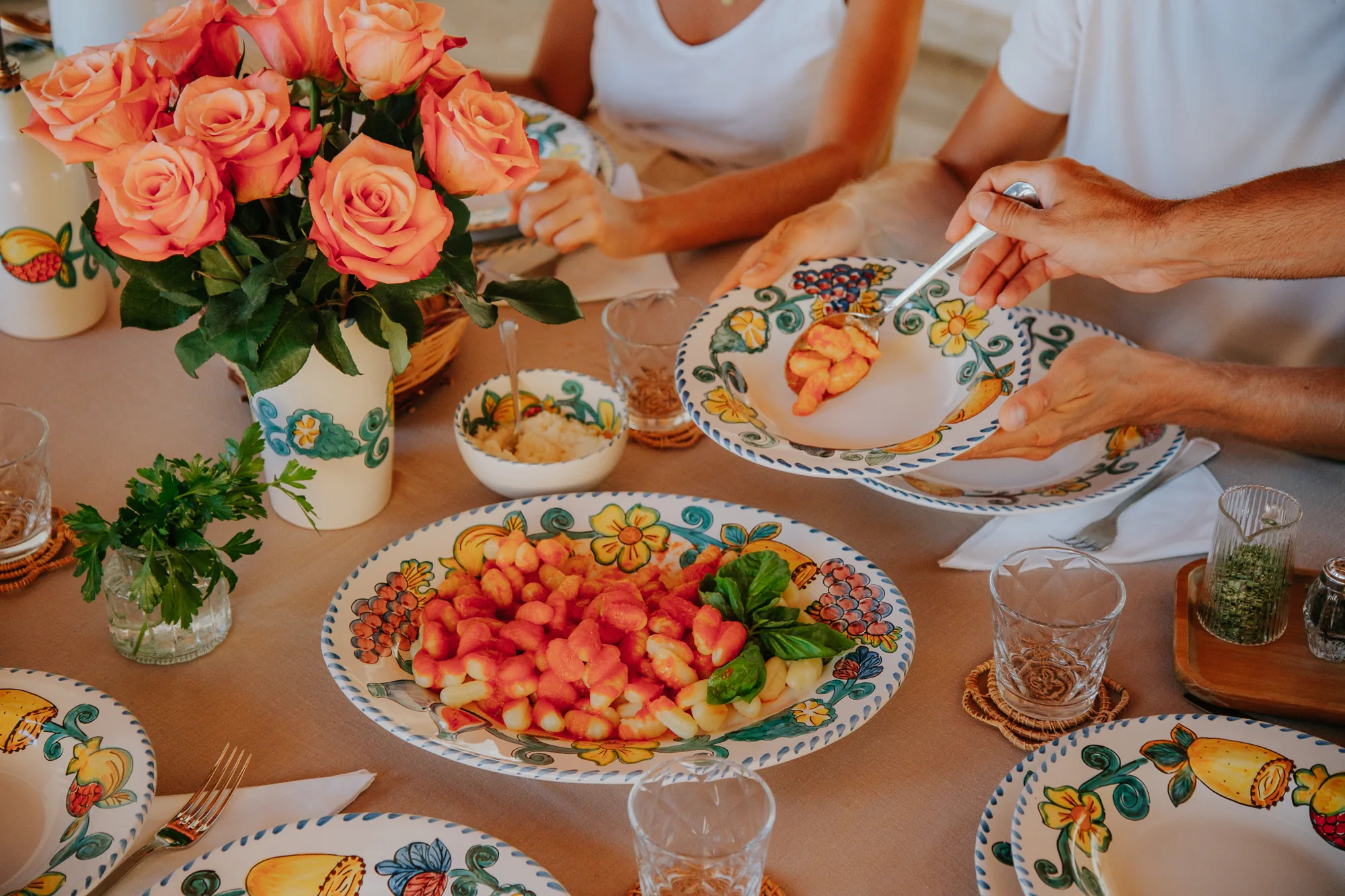 On sert les gnocchis à la tomate dans la vaisselle Frutta del Sud, autour d’un bouquet de roses