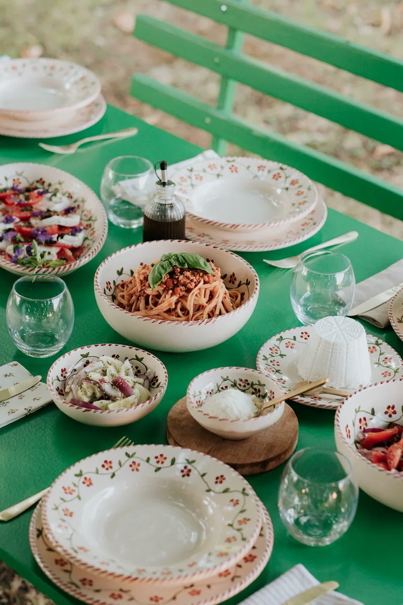 Pâtes, burrata et vaisselle Profumo di Primavera sur une table verte