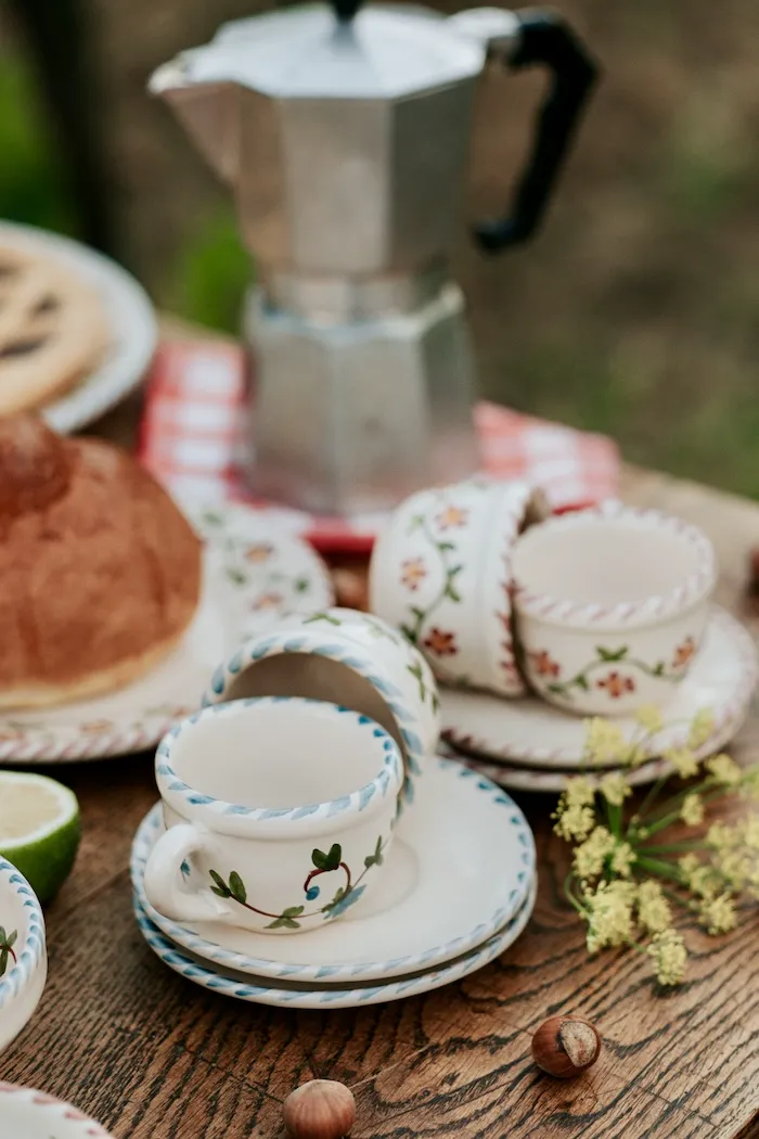 Tasses et soucoupes peintes à la main sur une table de petit-déjeuner