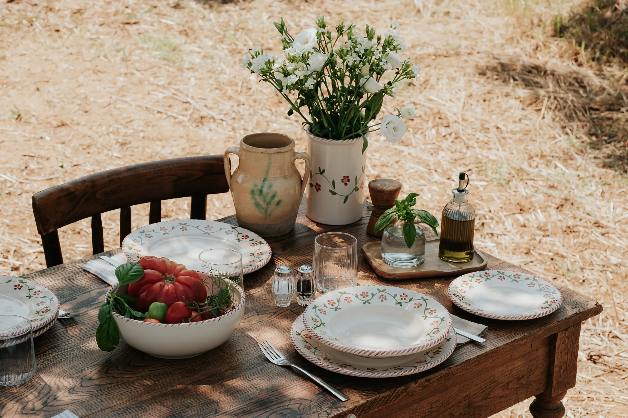 Table dressée dans une oliveraie avec la vaisselle Profumo di Primavera